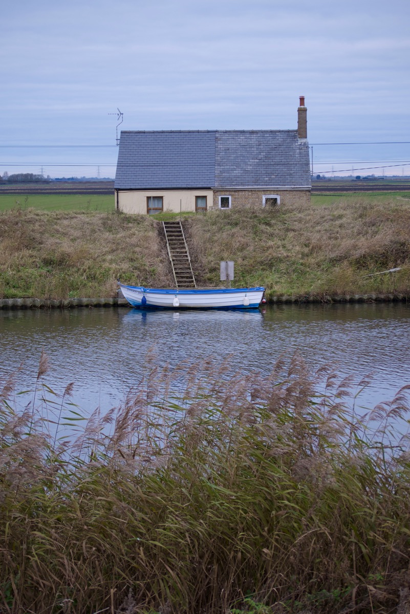 Fenland house, with boat moored on river outside
